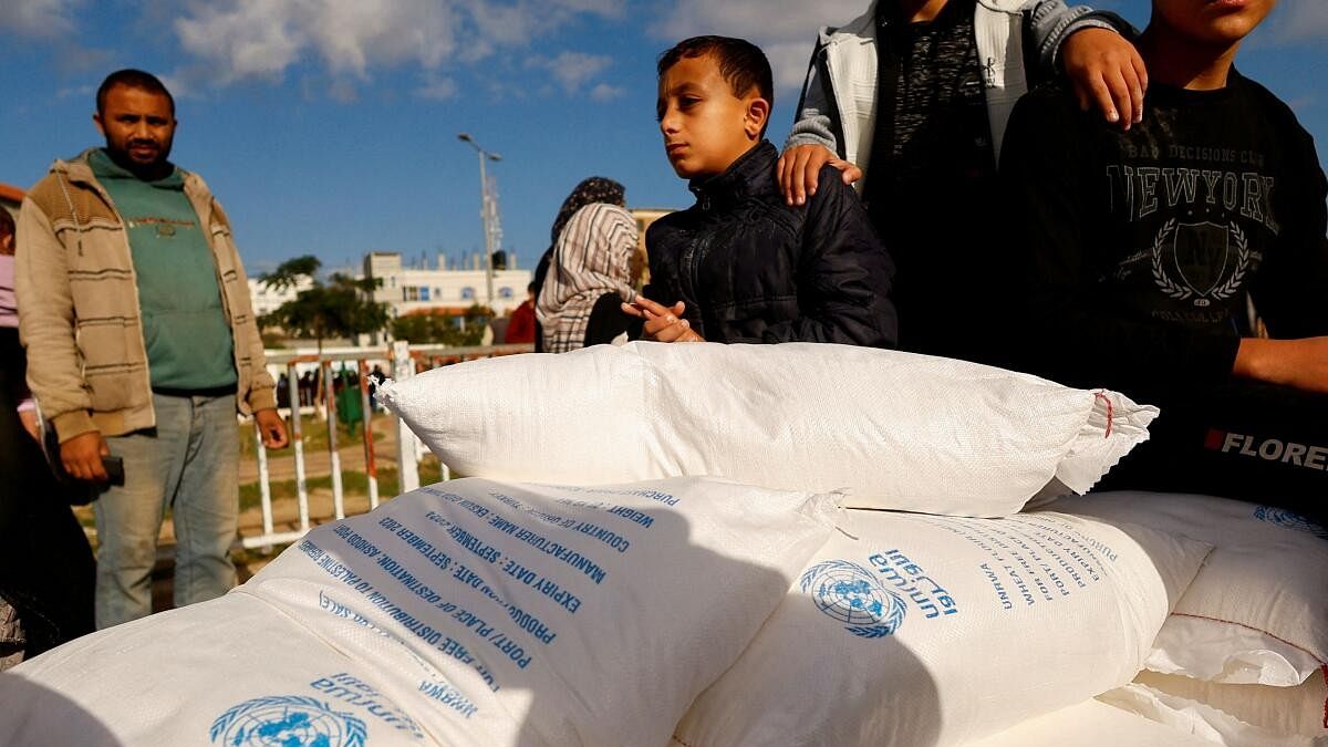 <div class="paragraphs"><p>Palestinians receive flour bags distributed by UNRWA in Rafah, in the southern Gaza Strip.</p></div>