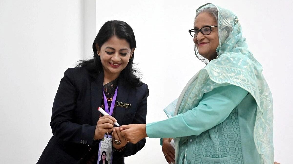 <div class="paragraphs"><p>An officer puts an ink mark on the thumb of Sheikh Hasina, Prime Minister of Bangladesh and Chairperson of Bangladesh Awami League, at the Dhaka City College center during the 12th general election in Dhaka, Bangladesh, January 7, 2024.</p></div>