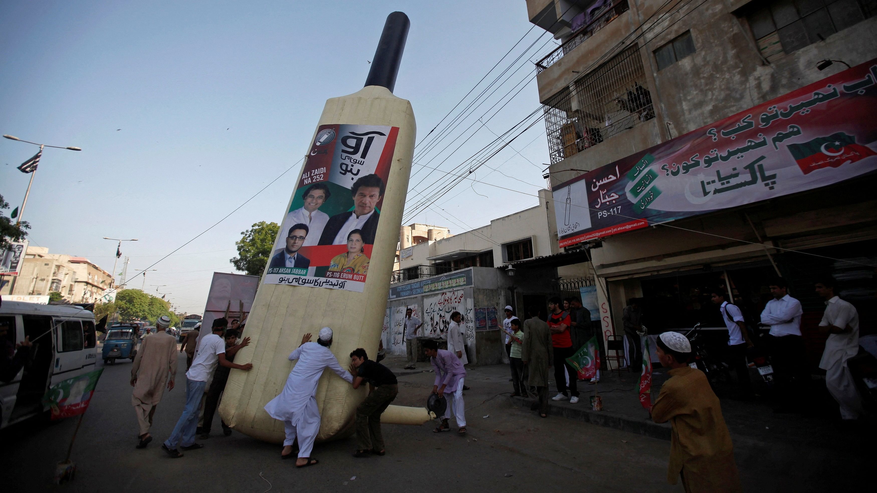 <div class="paragraphs"><p>File Photo: Supporters of Imran Khan, Pakistani cricketer-turned-politician and chairman of political party Pakistan Tehreek-e-Insaf, install a giant bat symbol along a roadside in Karachi May 4, 2013. </p></div>