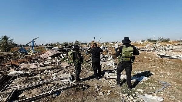 <div class="paragraphs"><p>Fighters of the Iraqi Kataib Hezbollah militia group and a man inspect the site of a US airstrike, in Hilla, Iraq.</p></div>