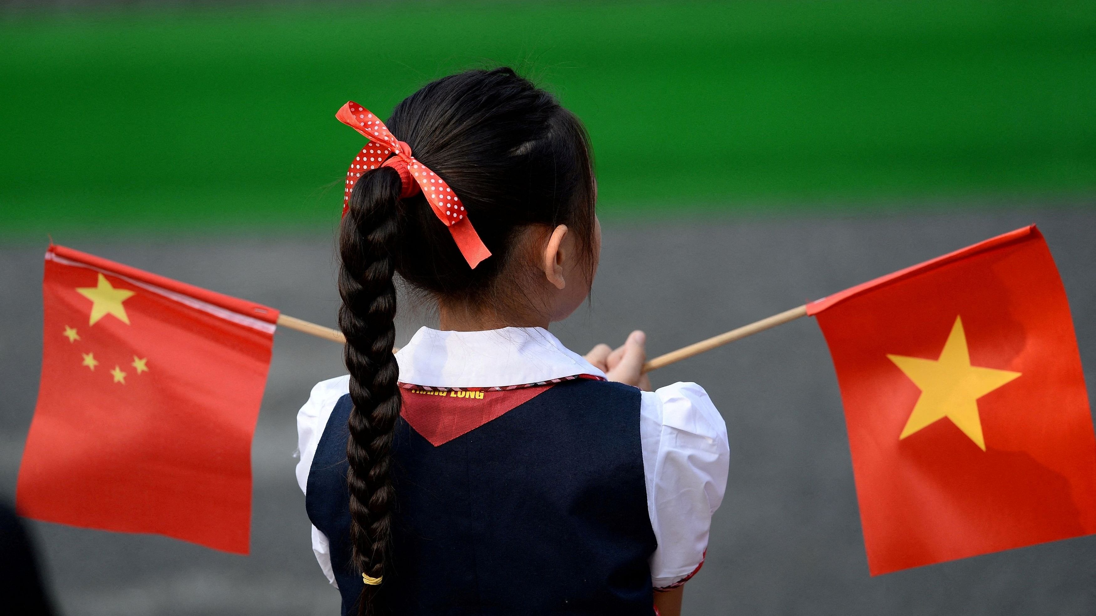 <div class="paragraphs"><p>A Vietnamese pupil holds Vietnamese and Chinese flags.</p></div>