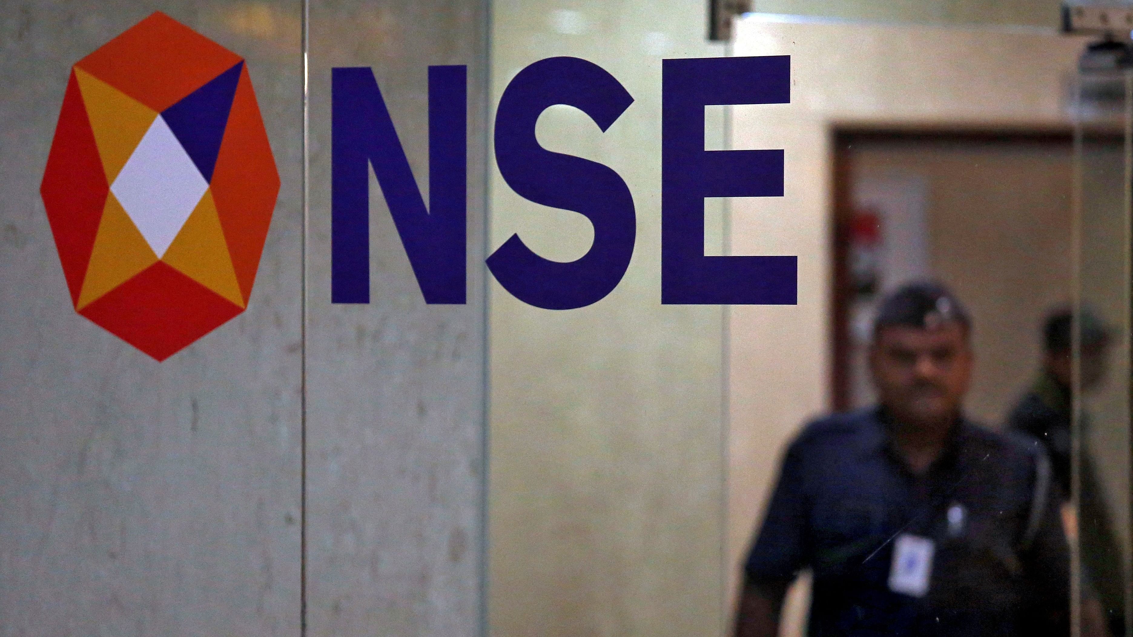 <div class="paragraphs"><p>A security guard walks past the logo of the National Stock Exchange inside its building in Mumbai.</p></div>