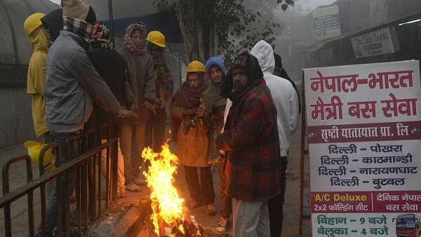 <div class="paragraphs"><p>People huddle around a bonfire amid fog on a cold winter morning, in New Delhi.</p></div>