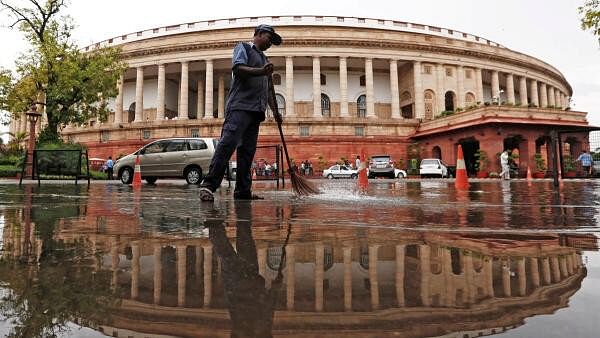 <div class="paragraphs"><p>Indian parliament building is reflected in a puddle after the rain as a man sweeps the water in New Delhi.</p></div>