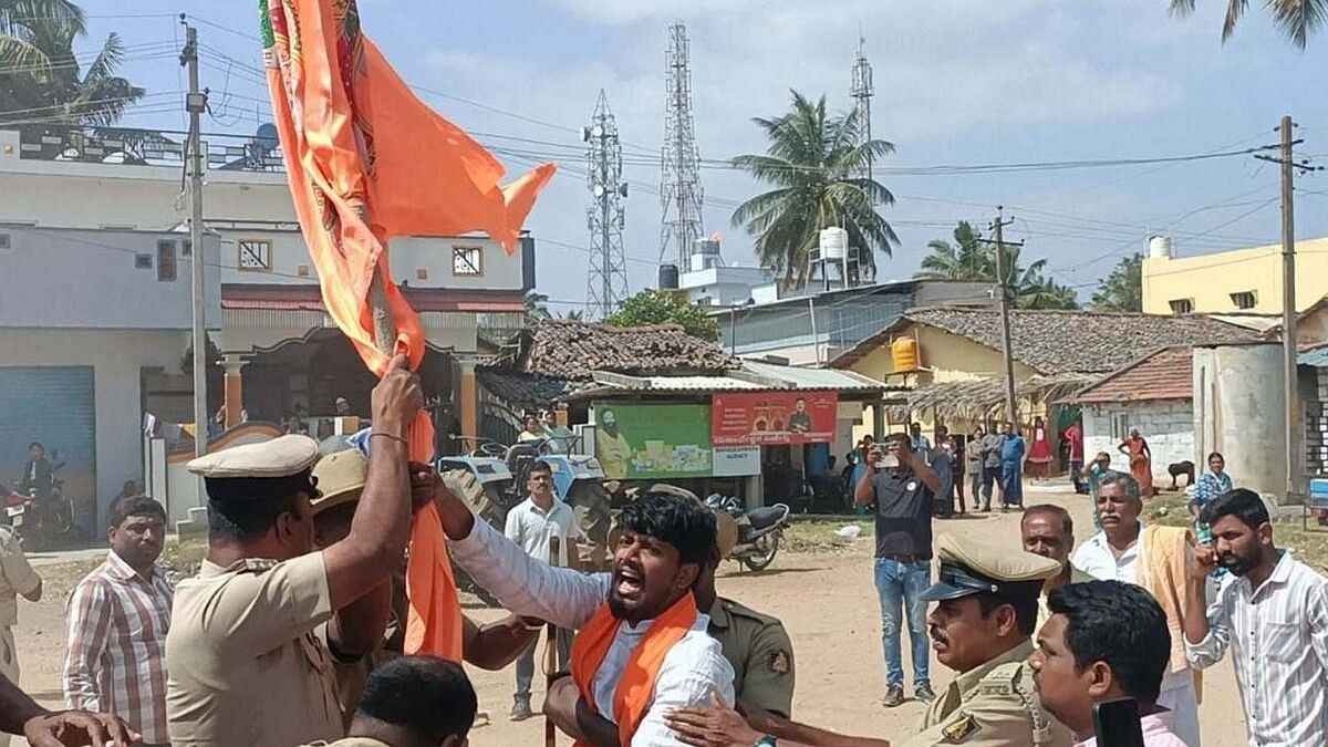 <div class="paragraphs"><p>A protester is trying to free the Hanuman flag from the police in Mandya.</p></div>