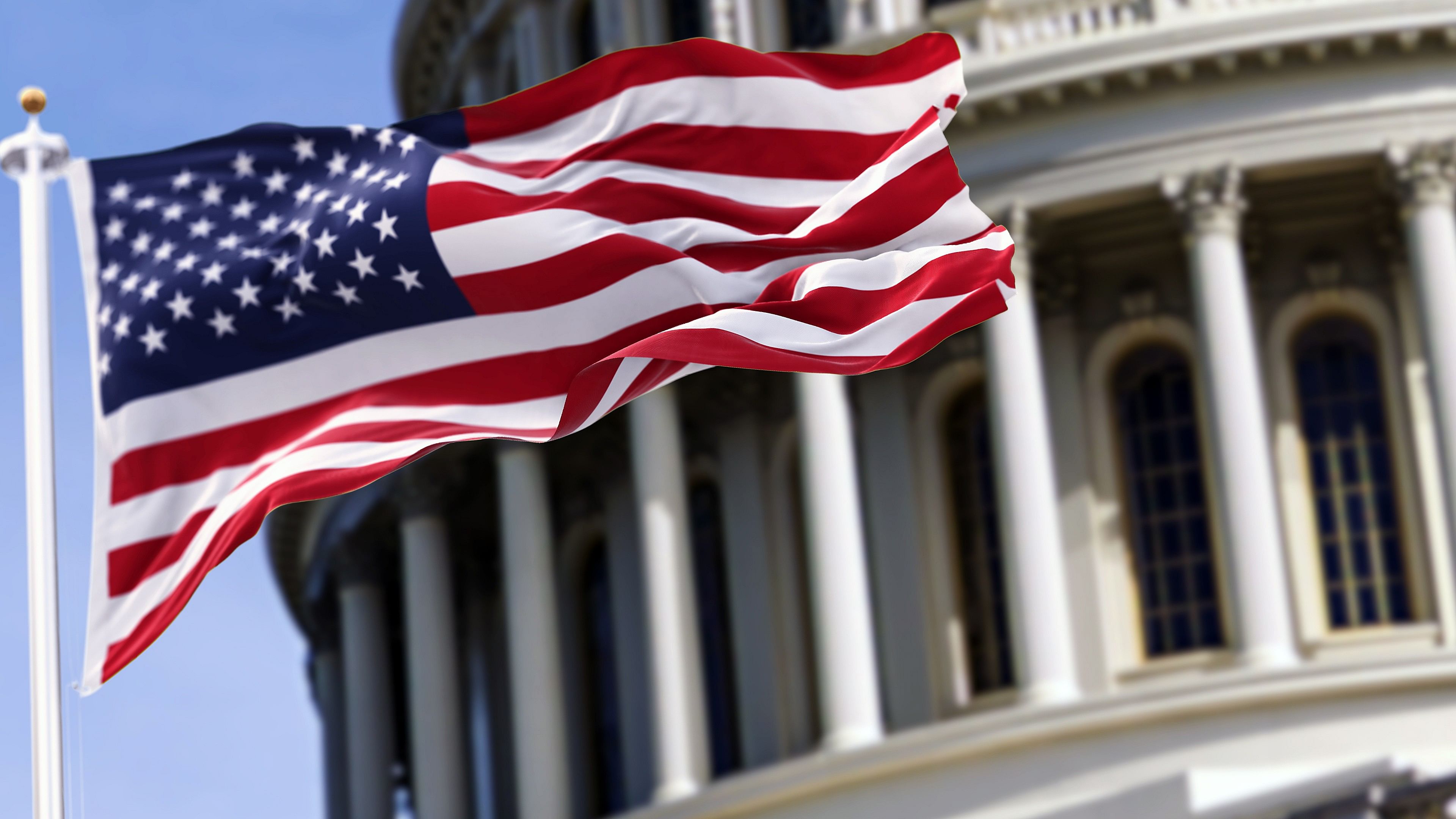 <div class="paragraphs"><p>The flag of the US flying in front of the Capitol building.</p></div>