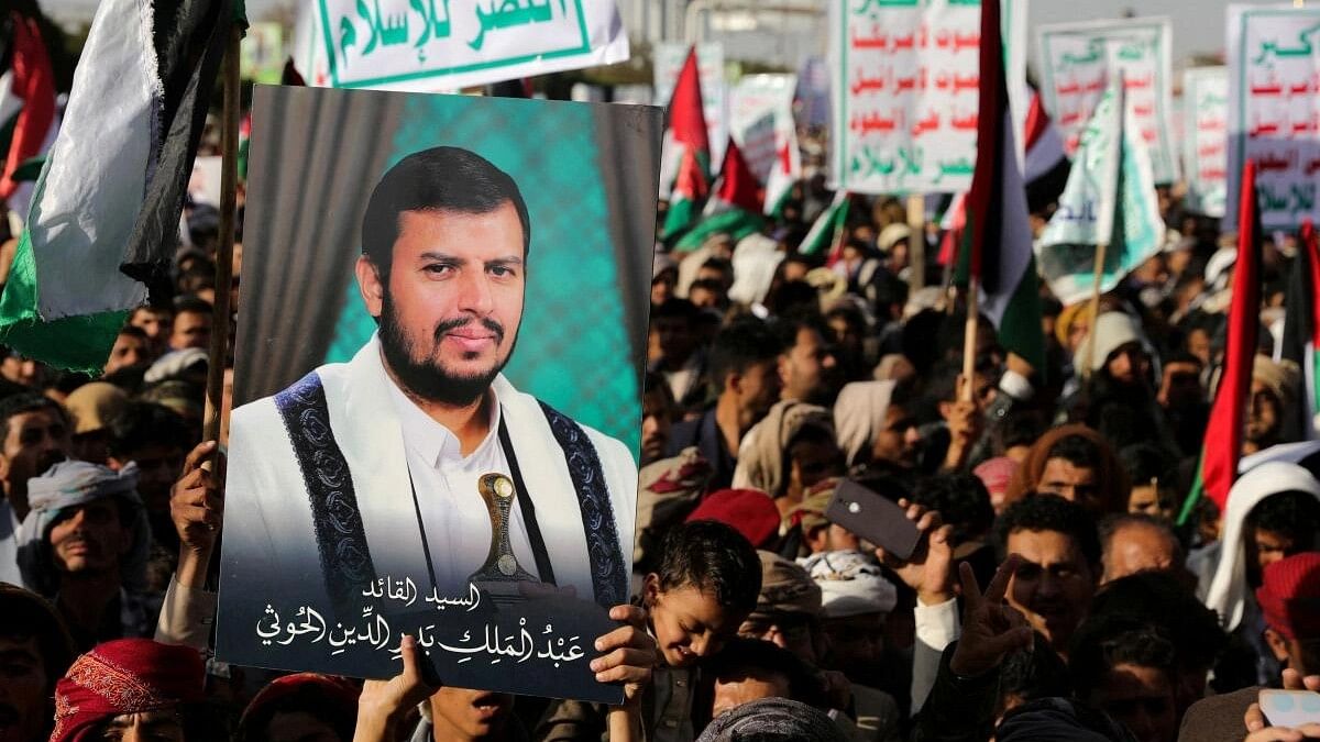 <div class="paragraphs"><p>A person holds a placard with a picture of Yemen's Houthi movement leader Abdul-Malik al-Houthi, as supporters of the Houthi movement rally to denounce air strikes launched by the US and Britain on Houthi targets, in Sanaa, Yemen.</p></div>