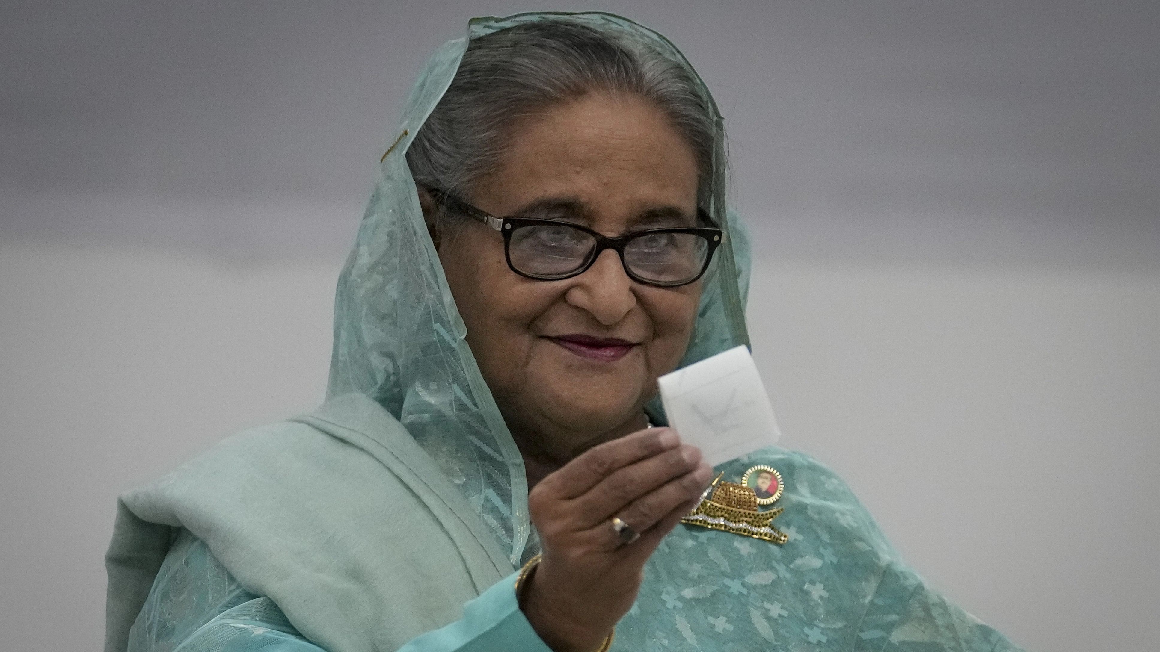 <div class="paragraphs"><p>Bangladesh Prime Minister Sheikh Hasina shows her ballot paper as she casts her vote in Dhaka, Bangladesh, Sunday, Jan. 7, 2024. </p></div>