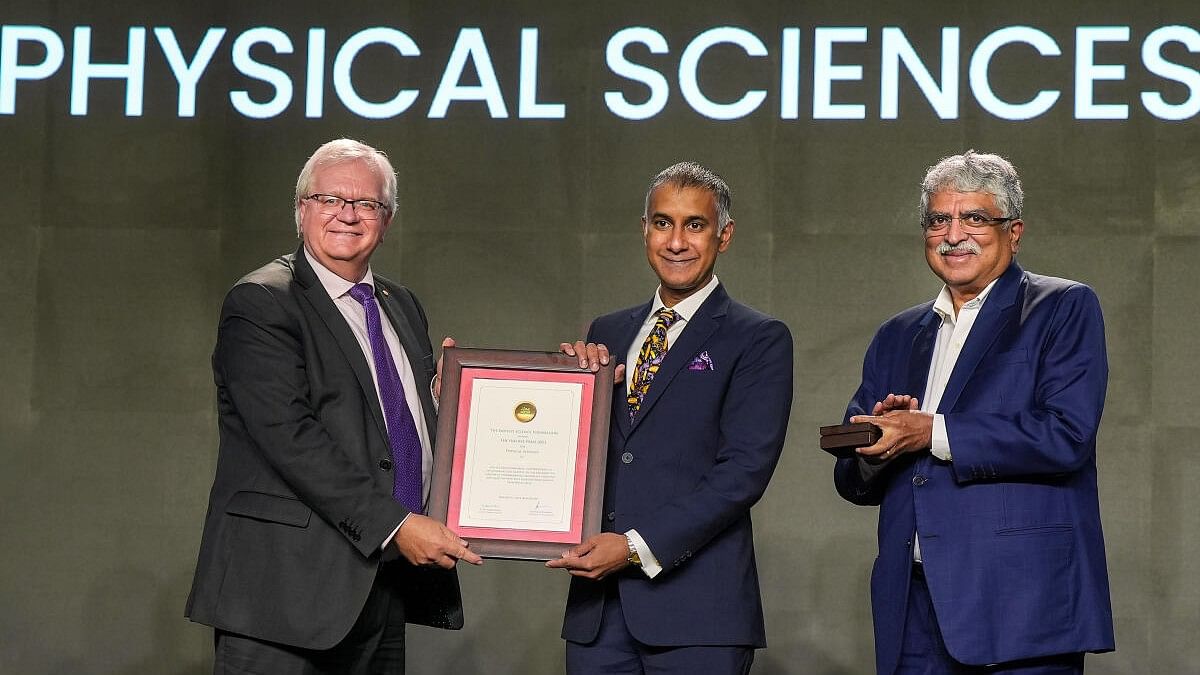 <div class="paragraphs"><p>Nobel Laureate Brian Schmidt hands over the Infosys Award to Mukund Thattai in Physical Sciences category as trustee Nandan Nilekani looks on during the Infosys Science foundation prize ceremony, in Bengaluru.</p></div>