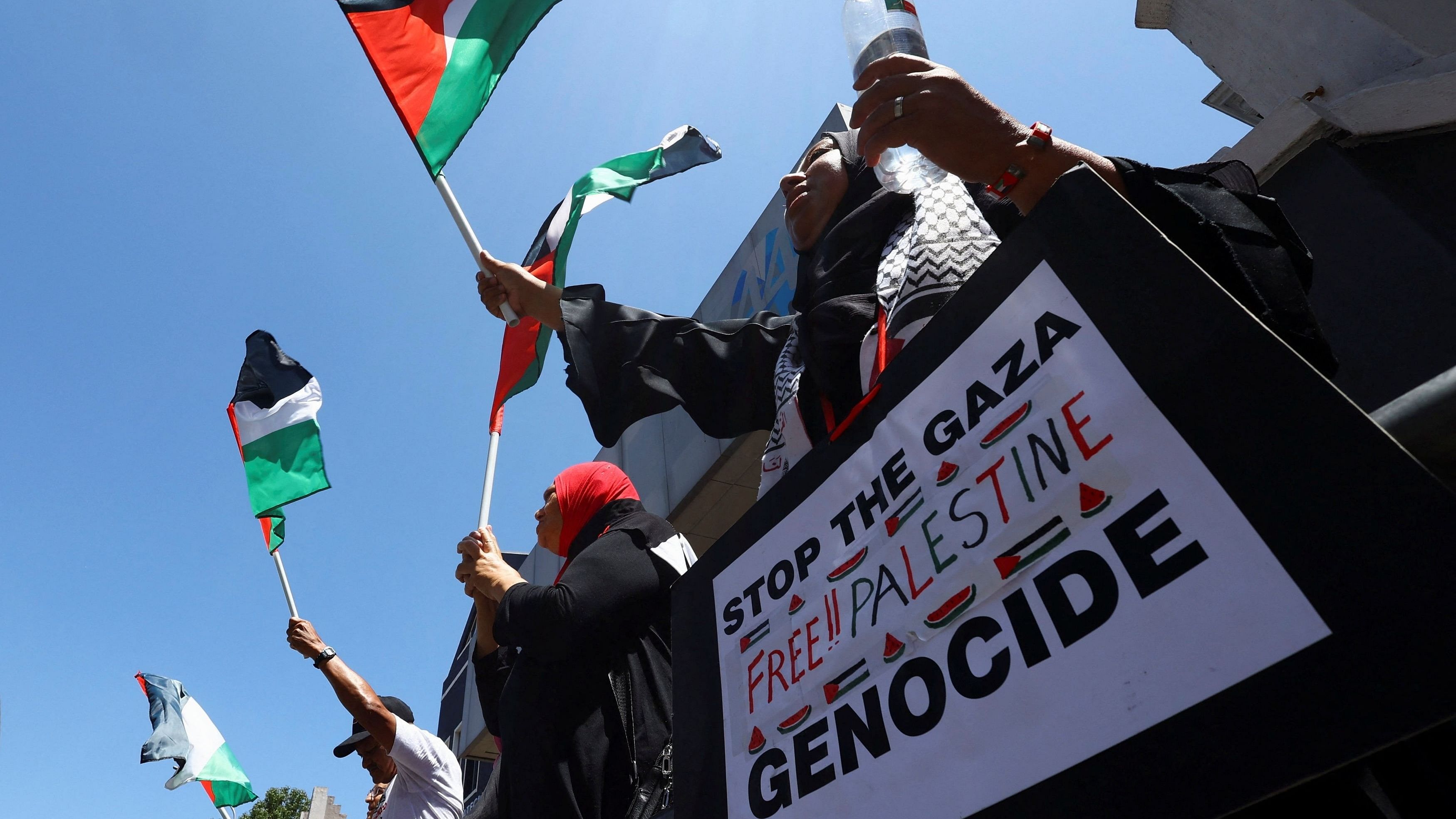 <div class="paragraphs"><p>People hold placards and Palestinian flags outside the Claremont mosque to express support for the people of Palestine, ahead of a ruling at the World Court on urgent measures on a case in which Israel is accused of genocide, in Cape Town, South Africa, January 26, 2024. </p></div>