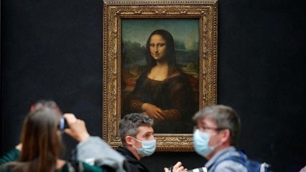 <div class="paragraphs"><p>Media people, wearing protective face masks, stand in front of the painting "Mona Lisa" (La Joconde) by Leonardo Da Vinci at the Louvre museum in Paris.</p></div>
