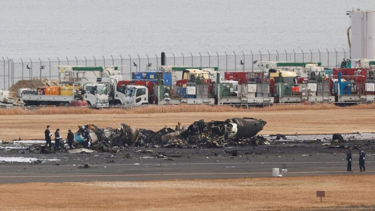 <div class="paragraphs"><p>Officials investigate a burnt Japan Coast Guard aircraft after a collision with Japan Airlines Airbus A350 plane at Haneda airport in Tokyo.</p></div>