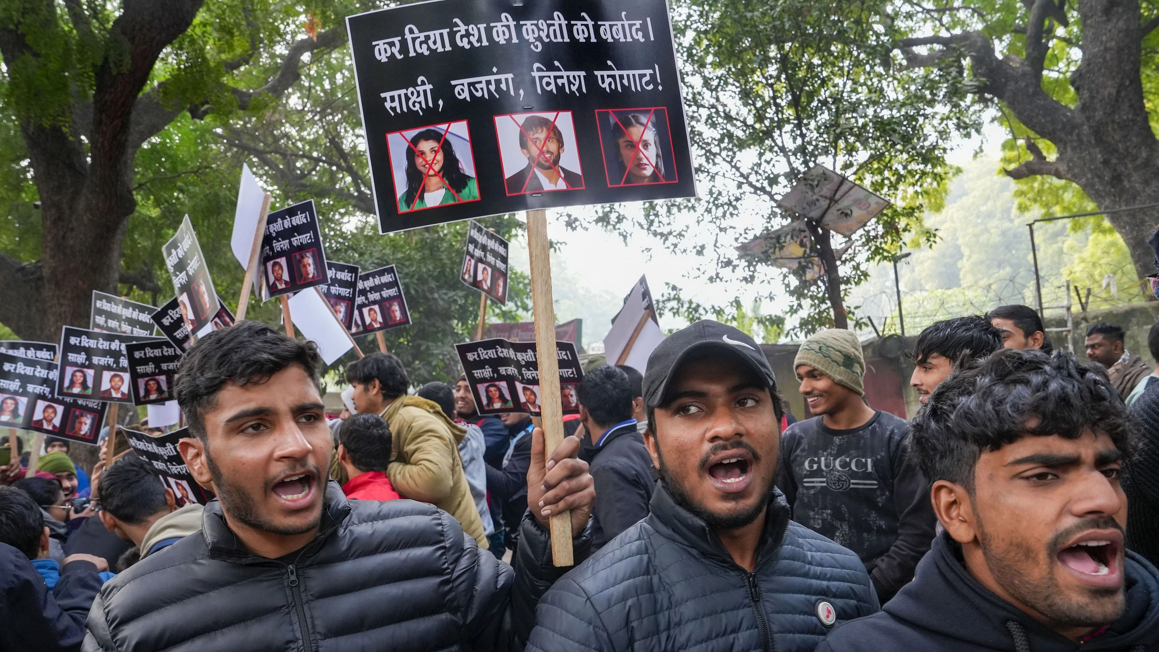 <div class="paragraphs"><p>Wrestlers hold placards during a protest against wrestlers Sakshi Malik, Bajrang Punia and Vinesh Phogat at Jantar Mantar in New Delhi on Wednesday.</p></div>