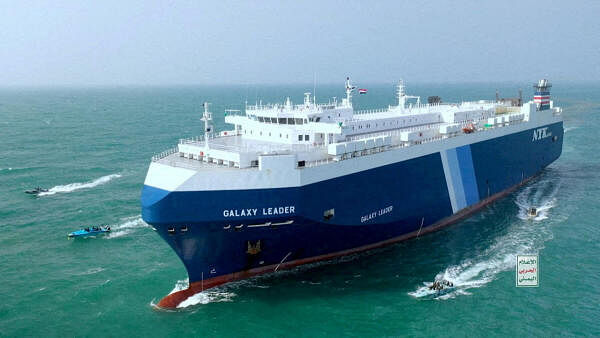 <div class="paragraphs"><p>A cargo ship being escorted by Houthi boats in the Red Sea.</p></div>