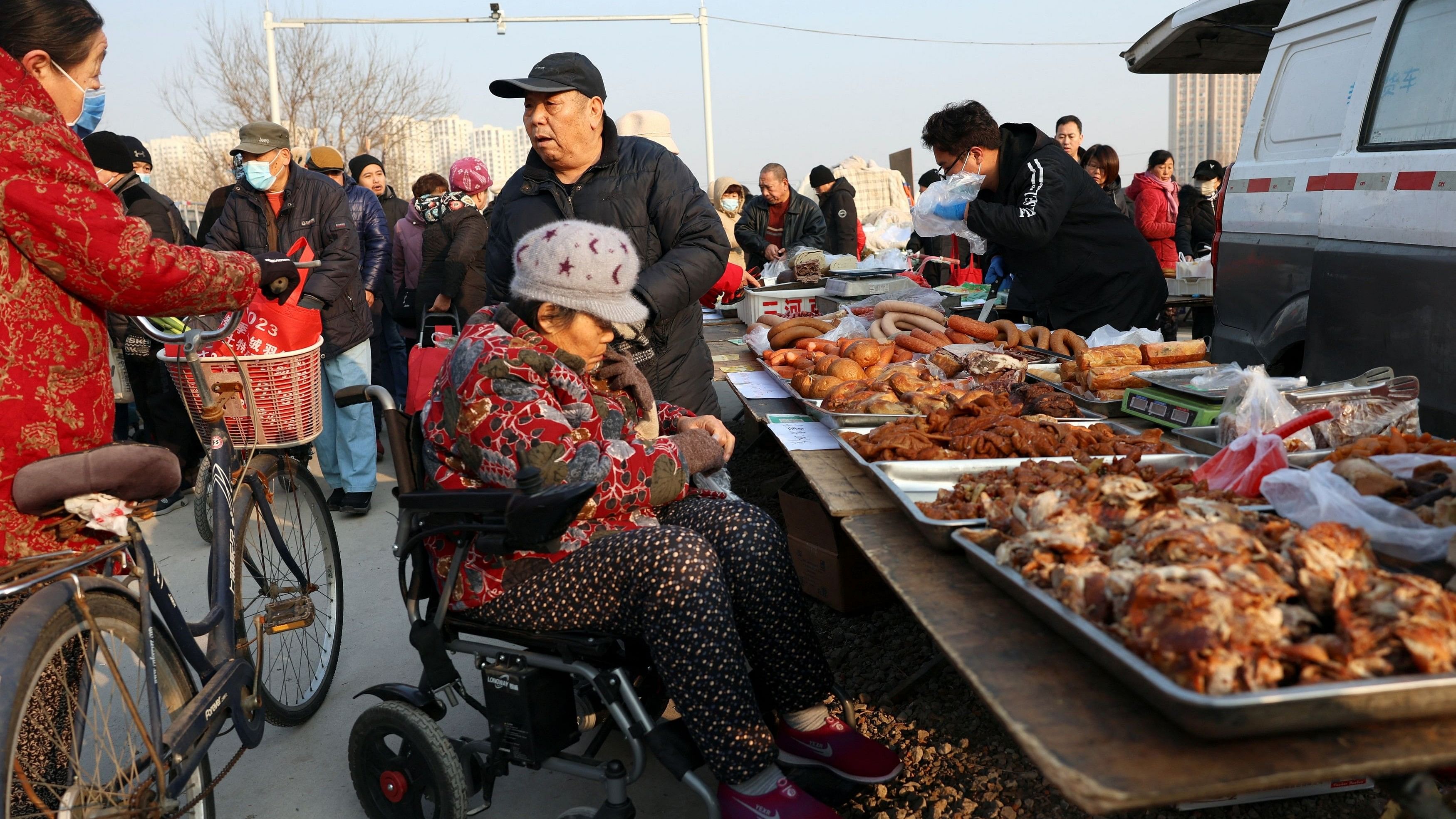 <div class="paragraphs"><p>Elderly people chat next to a food stall at an outdoor market in Beijing, China.</p></div>