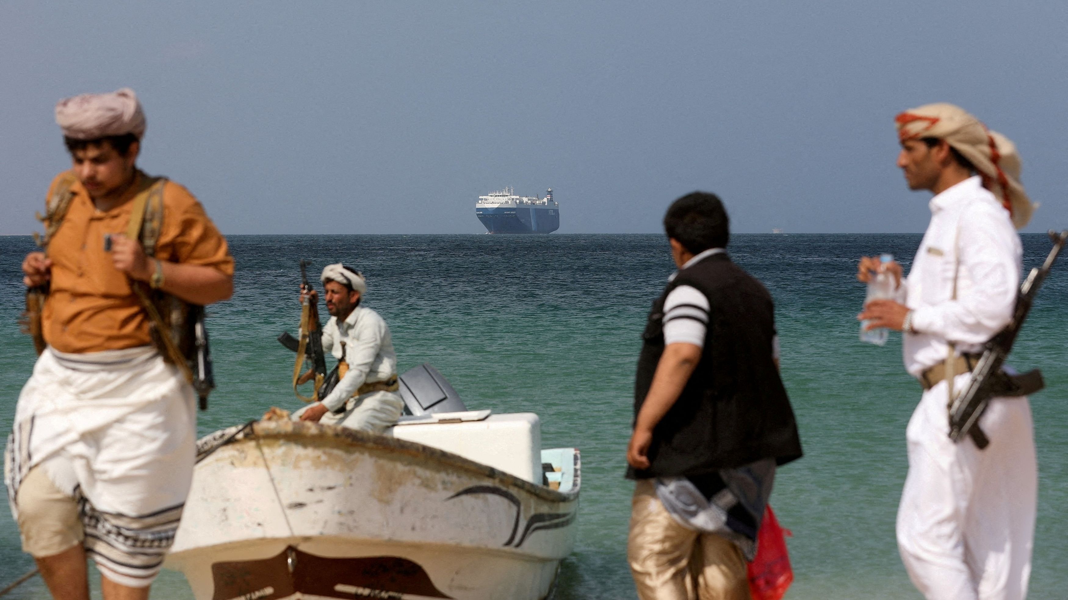 <div class="paragraphs"><p>Armed men stand on the beach as the Galaxy Leader commercial ship, seized by Yemen's Houthis last month, is anchored off the coast of al-Salif, Yemen, December 5, 2023.</p></div>