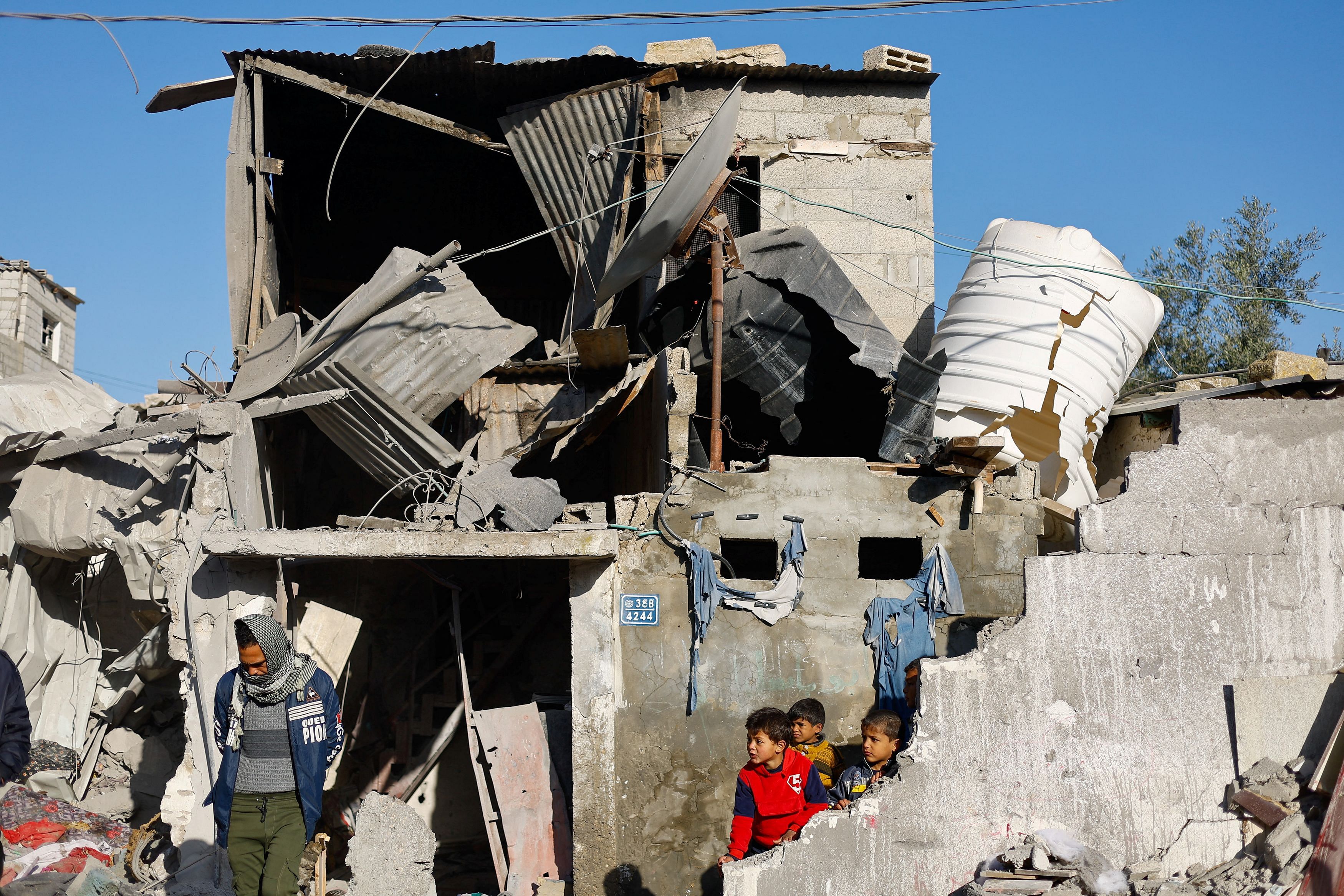 Children look on at the site of an Israeli strike on a house, amid the ongoing conflict between Israel and the Palestinian Islamist group Hamas, in Rafah in the southern Gaza Strip, January 18, 2024. REUTERS/Mohammed Salem