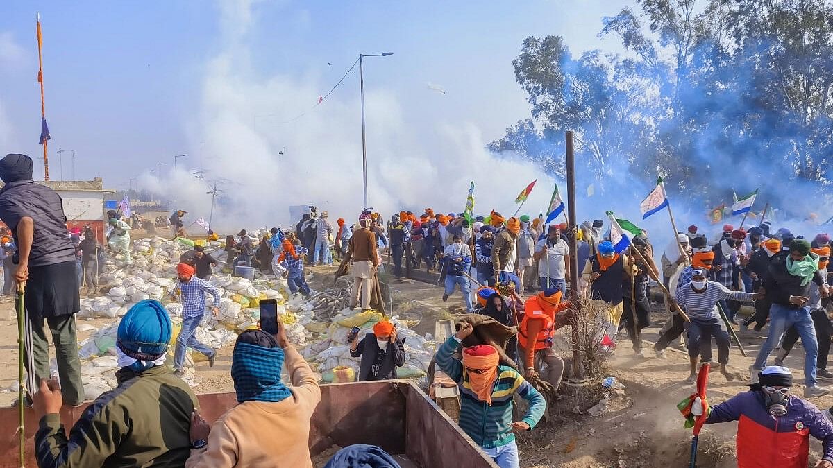 <div class="paragraphs"><p>Farmers look for cover after police fired tear gas at them during their 'Delhi Chalo' march.</p></div>