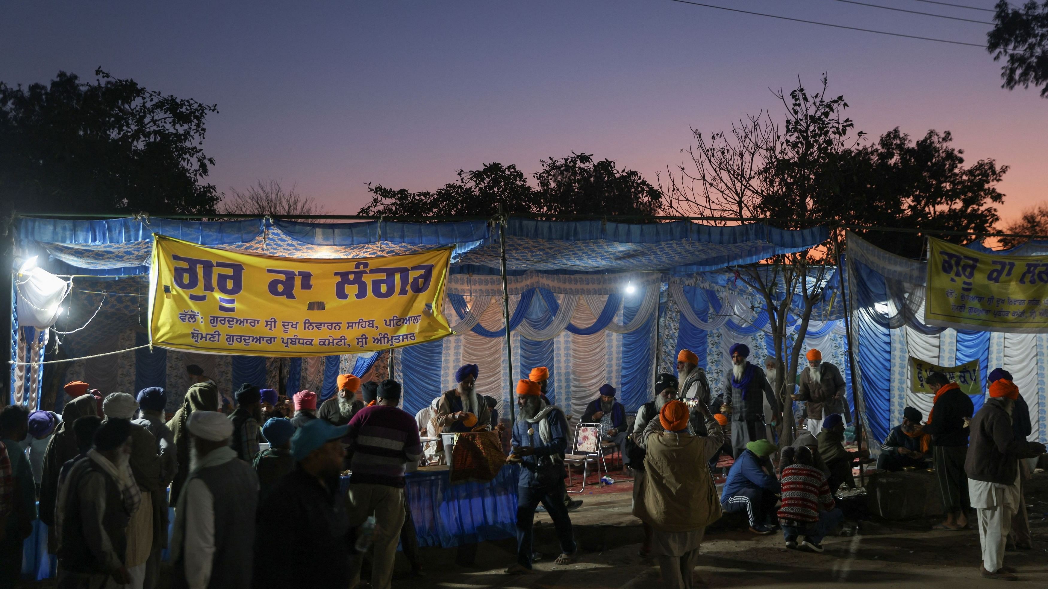 <div class="paragraphs"><p>Farmers stand in a line as volunteers distribute food at a protest site where they are marching towards New Delhi to press for the better crop prices promised to them in 2021, at Shambhu Barrier, a border between Punjab and Haryana, February 22, 2024. </p></div>