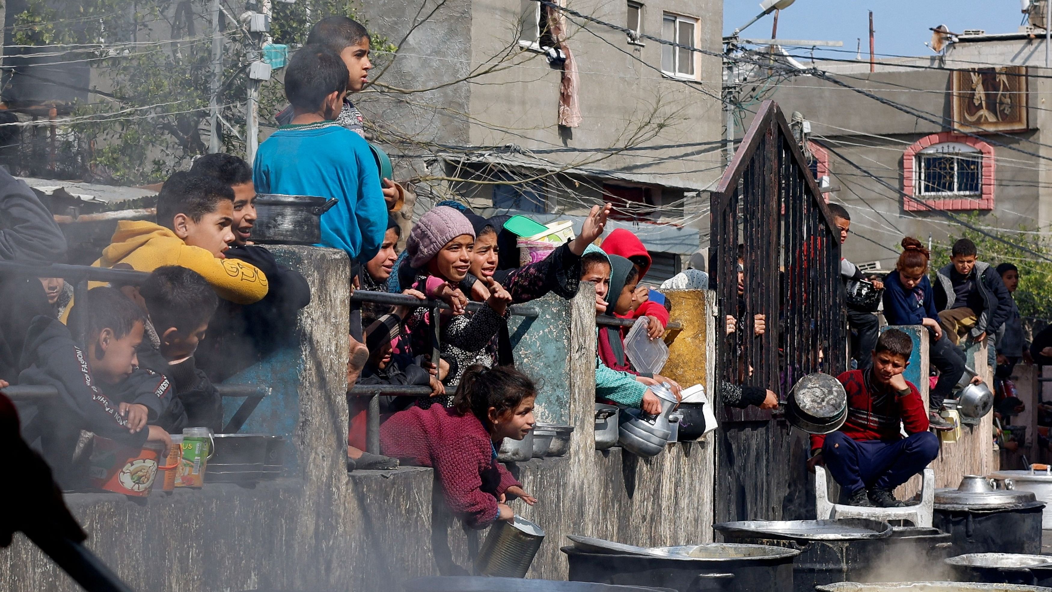 <div class="paragraphs"><p>Palestinian children wait to receive food cooked by a charity kitchen amid shortages of food supplies, as the ongoing conflict between Israel and the Palestinian Islamist group Hamas continues, in Rafah, in the southern Gaza Strip, February 20, 2024.</p></div>