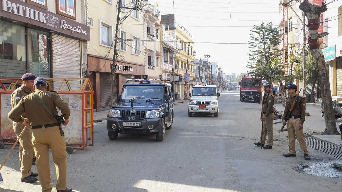 <div class="paragraphs"><p>Police personnel stand guard on a road during a curfew at Banbhoolpura area, following incidents of violence after the demolition of an 'illegally built' madrasa, in Haldwani.</p></div>