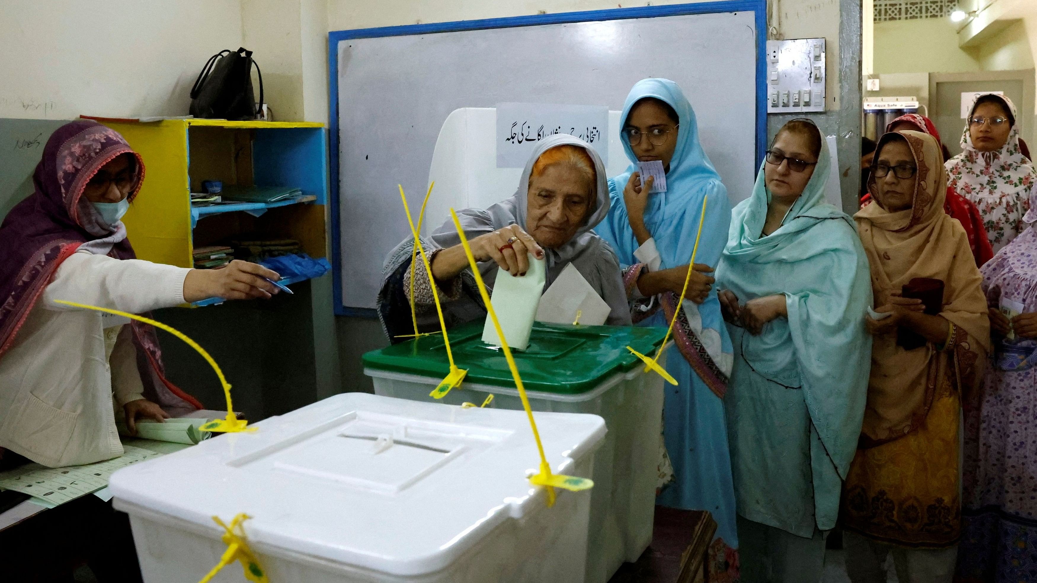 <div class="paragraphs"><p>A polling officer instructs a woman, as she casts her vote at a polling station during the general election in Pakistan.</p></div>