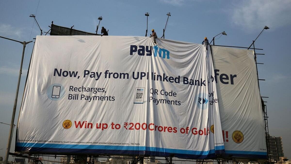 <div class="paragraphs"><p>Workers adjust a hoarding of Paytm, the digital payments firm.</p></div>