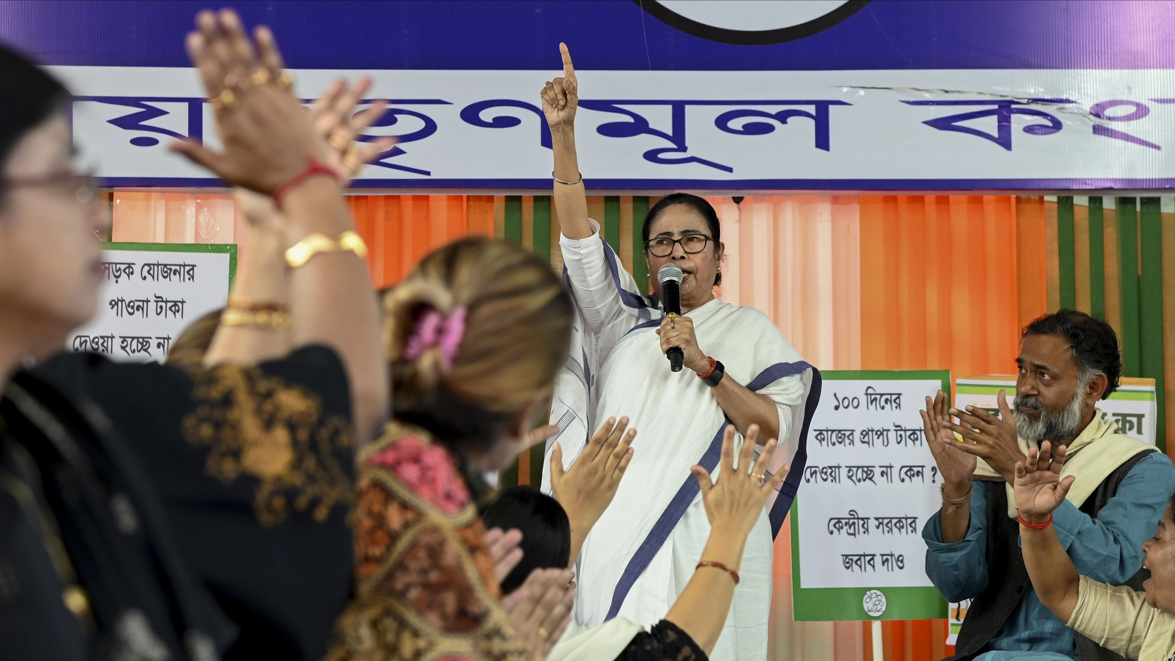 <div class="paragraphs"><p>West Bengal CM Mamata Banerjee speaks as activist Yogendra Yadav applauds during a dharna demanding the state's dues from the Centre for various social welfare schemes, in Kolkata</p></div>