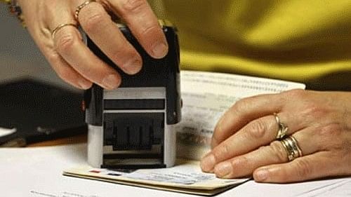 <div class="paragraphs"><p> A representative photo of a visa stamp being applied to a passport.</p></div>