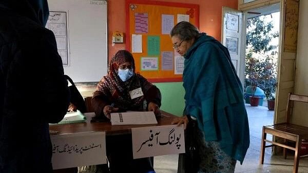 <div class="paragraphs"><p>Mumtaz, 86, a voter, speaks to an election worker at a polling station in a school on the day of the general election, in Islamabad, Pakistan February 8, 2024.</p></div>