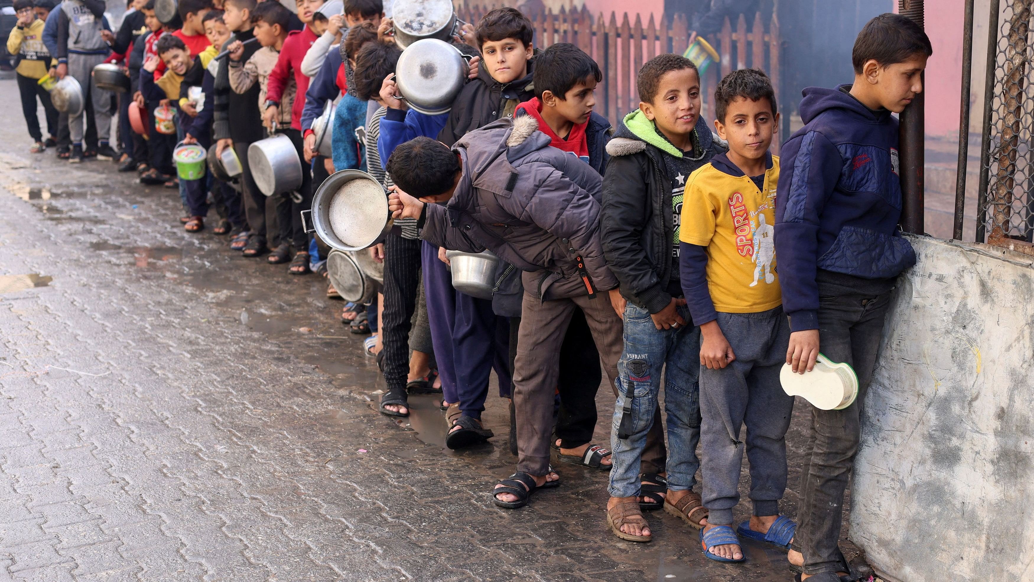 <div class="paragraphs"><p>A file photo of Palestinian children carry pots as they queue to receive food cooked by a charity kitchen, amid shortages in food supplies in Rafah in the southern Gaza Strip</p></div>