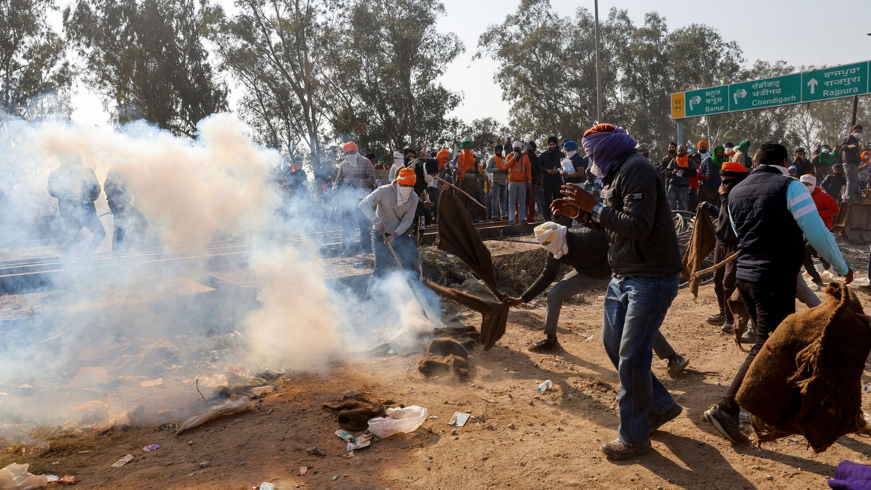 <div class="paragraphs"><p>Protesters trying to cover tear gas shells with cloths, as farmers march towards New Delhi.</p></div>