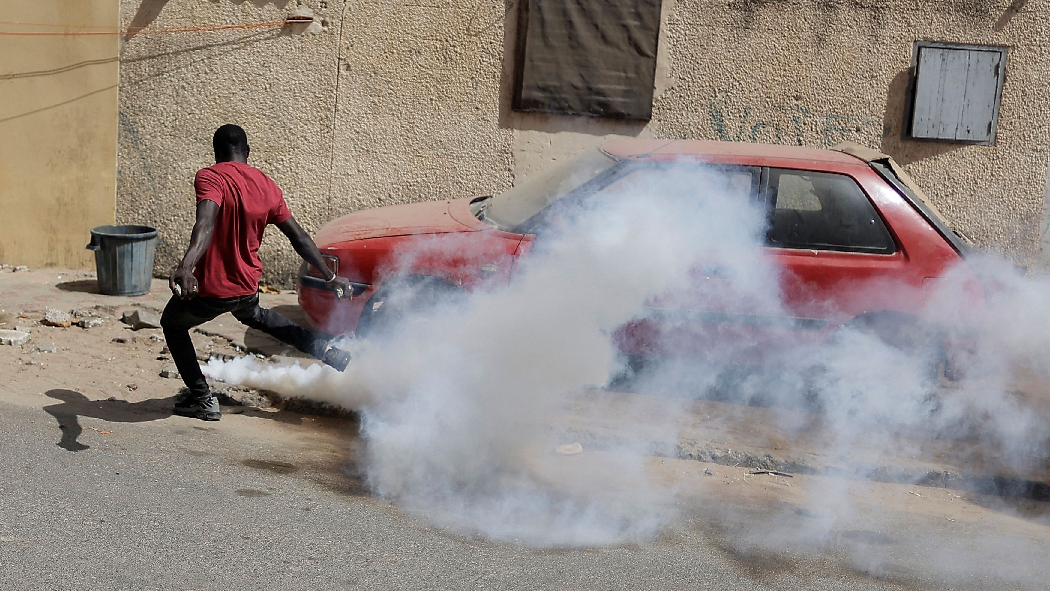 <div class="paragraphs"><p>A Senegalese demonstrator kicks a gas canister towards riot police as they protest against the postponement of presidential election in  Senegal.</p></div>