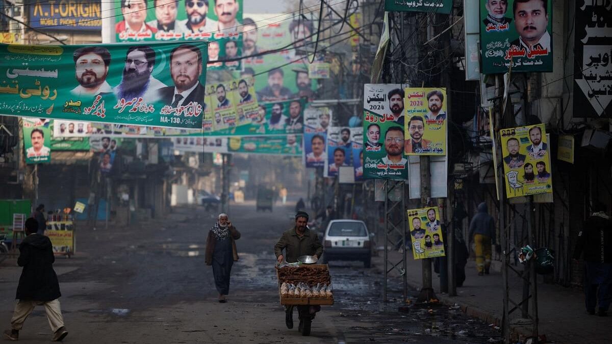 <div class="paragraphs"><p>A vendor pushes his cart on a street filled with campaign banners and posters of political parties in Pakistan.</p></div>