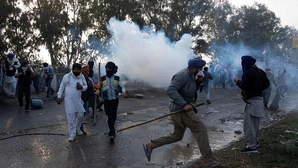 <div class="paragraphs"><p>Farmers, who are marching towards New Delhi, run for cover amidst tear gas smoke fired by police to disperse them at Shambhu, a border crossing between Punjab and Haryana.</p></div>