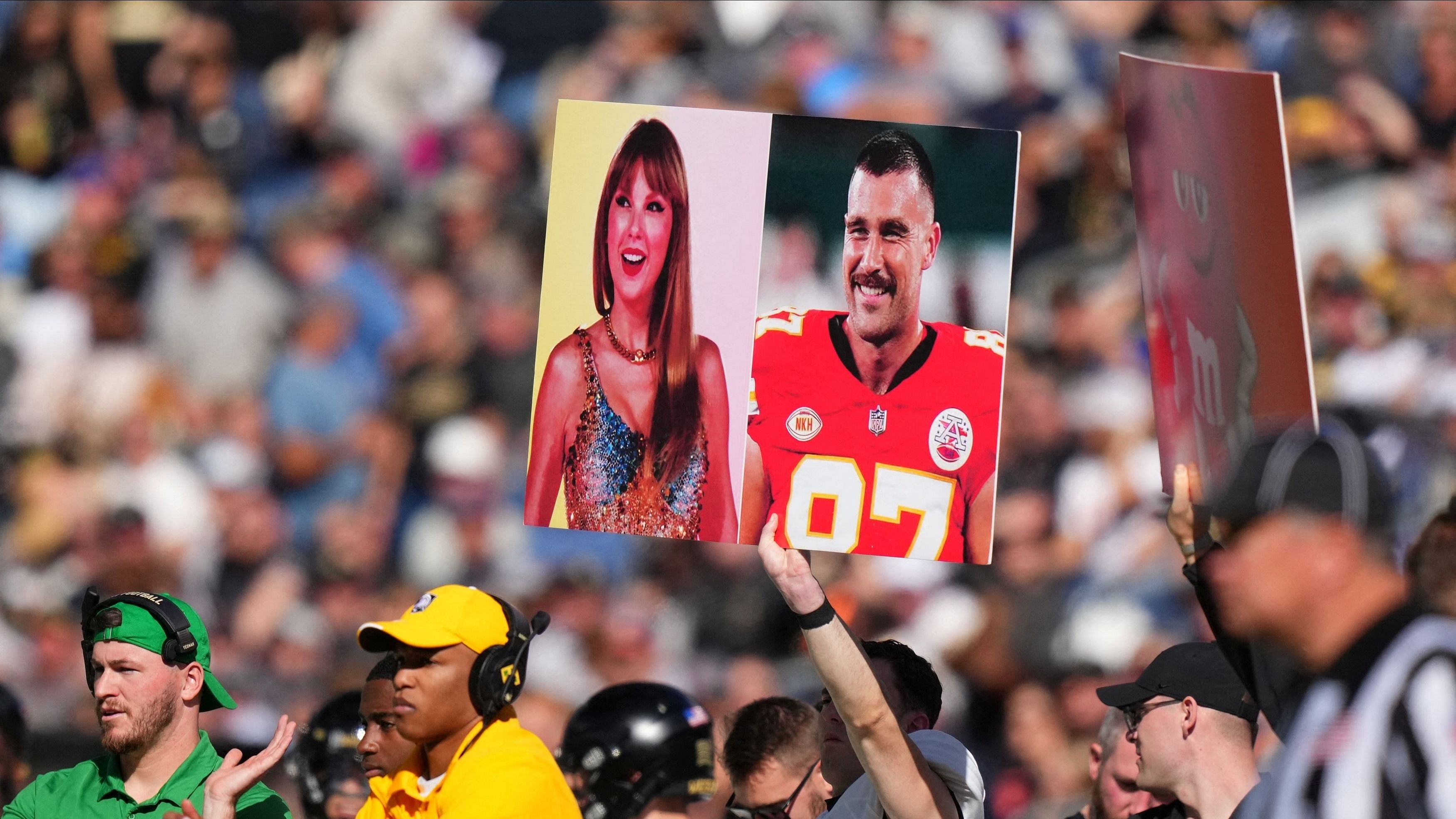 <div class="paragraphs"><p>Army Black Knights members hold up a call in play sign of American recording artist Taylor Swift and American football player Travis Kelce in the first half against the Air Force Falcons at Empower Field at Mile High.</p></div>