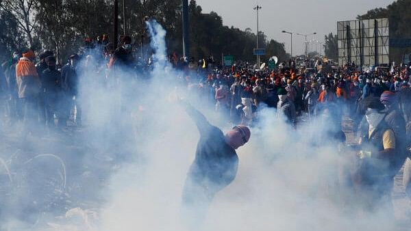 <div class="paragraphs"><p>People stand to throw jute bags at tear gas fired by the police to disperse farmers marching towards New Delhi.</p></div>