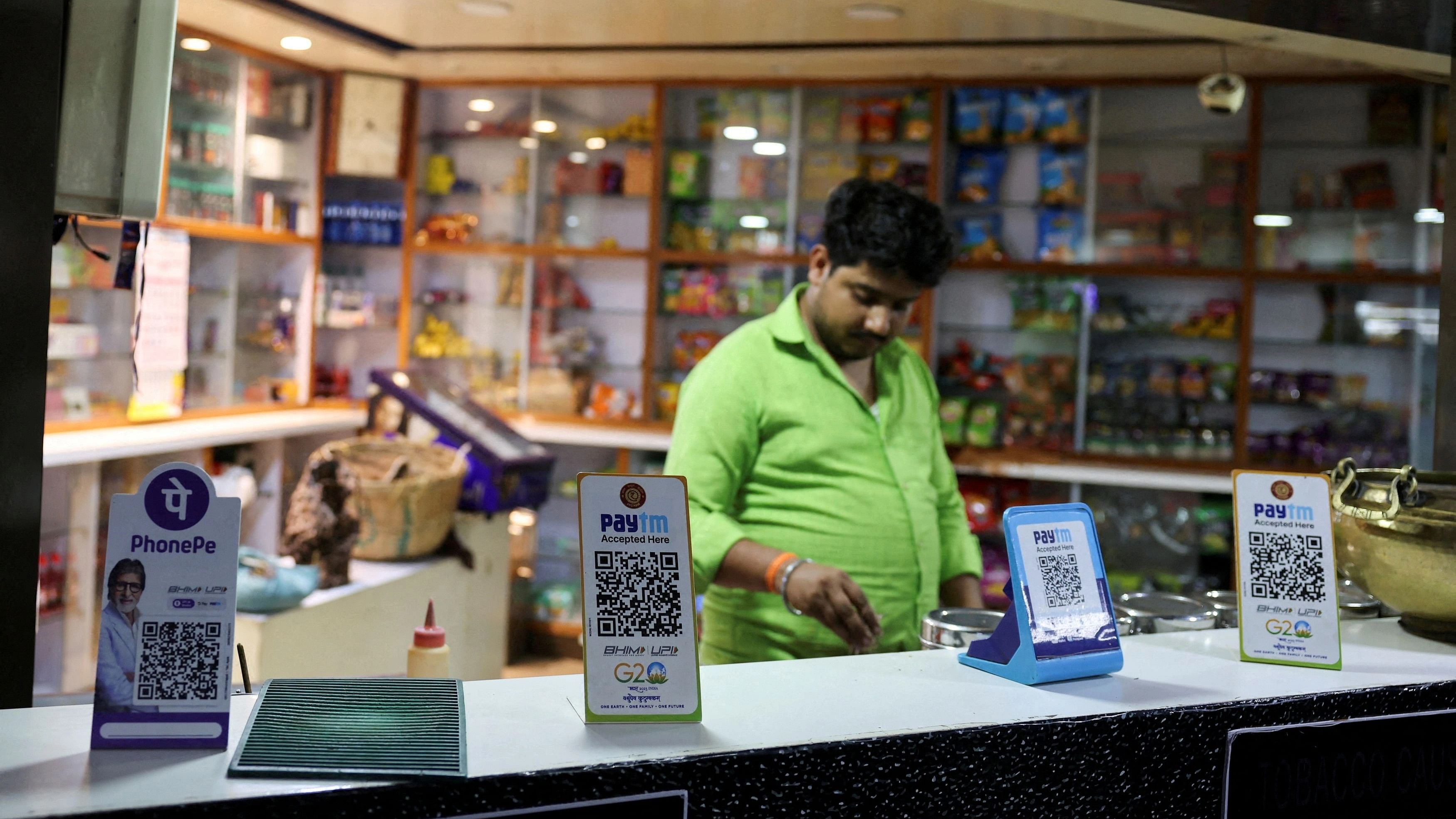 <div class="paragraphs"><p>QR codes of digital payment firms PhonePe and Paytm are seen on the counter of a grocery store.</p></div>