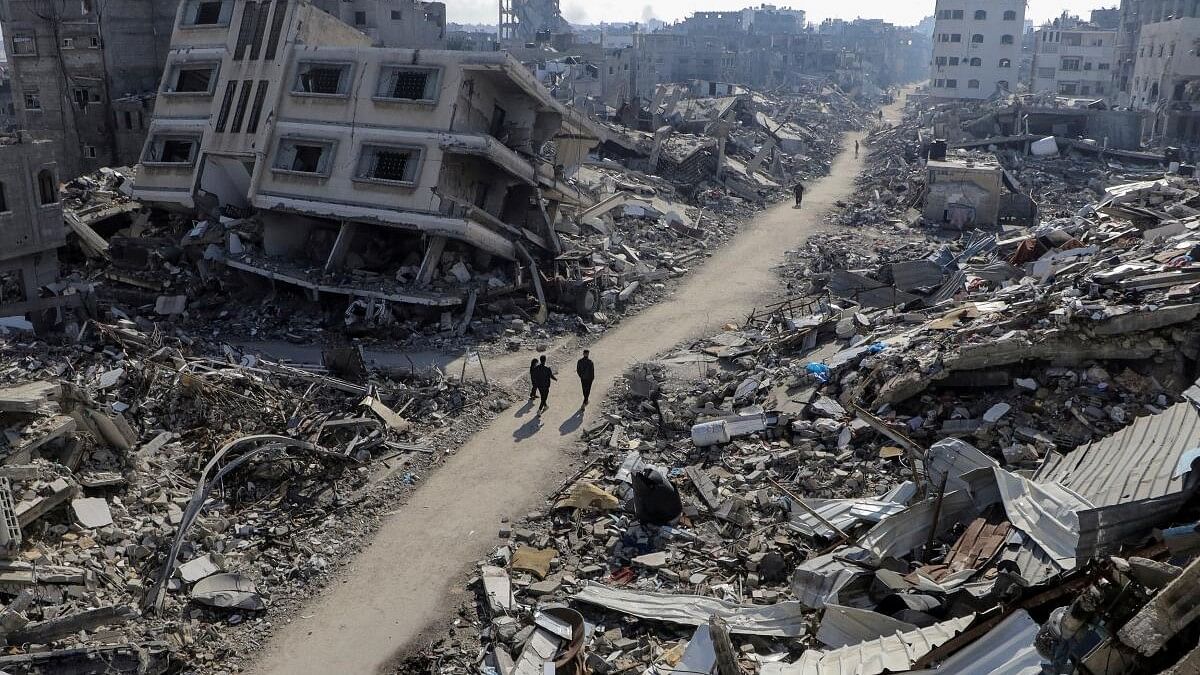 <div class="paragraphs"><p>Palestinians walk past destroyed houses, in Jabalia refugee camp.</p></div>