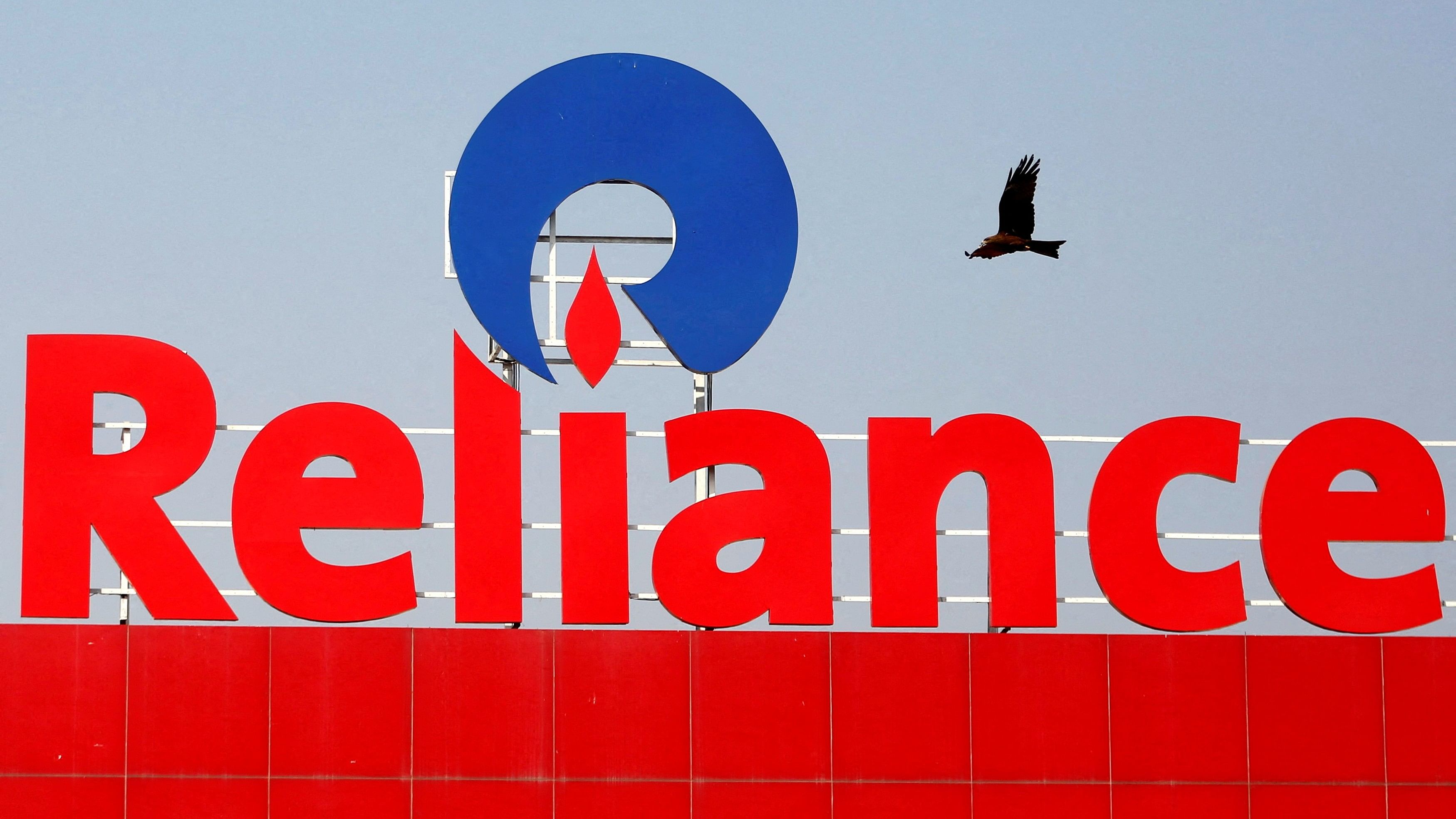 <div class="paragraphs"><p>A bird flies past a Reliance Industries logo installed on its mart in Ahmedabad</p></div>