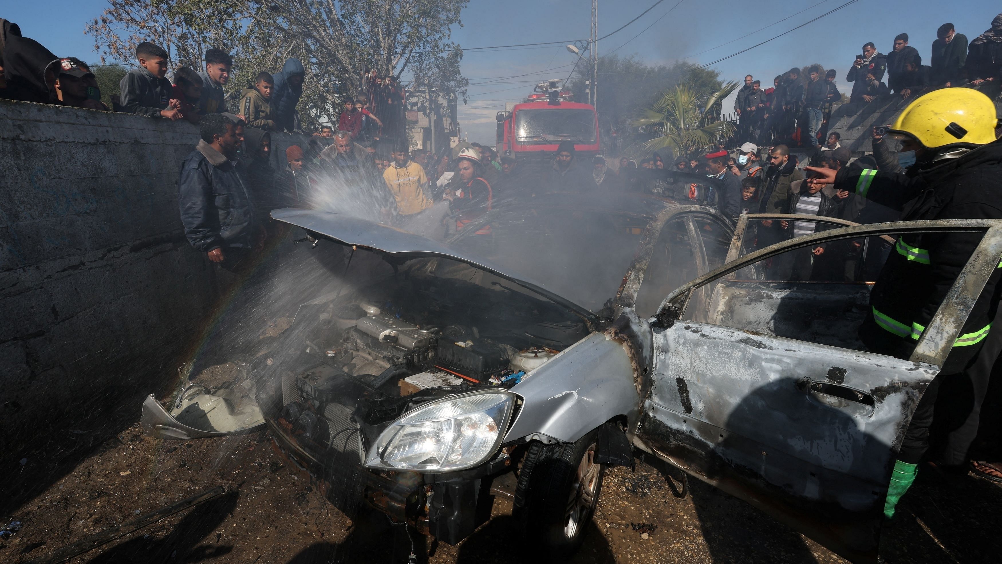 <div class="paragraphs"><p>Firefighters work as Palestinians gather around a car hit in an Israeli strike, amid the ongoing conflict between Israel and the Palestinian Islamist group Hamas, in Rafah in the southern Gaza Strip, February 4, 2024. </p></div>