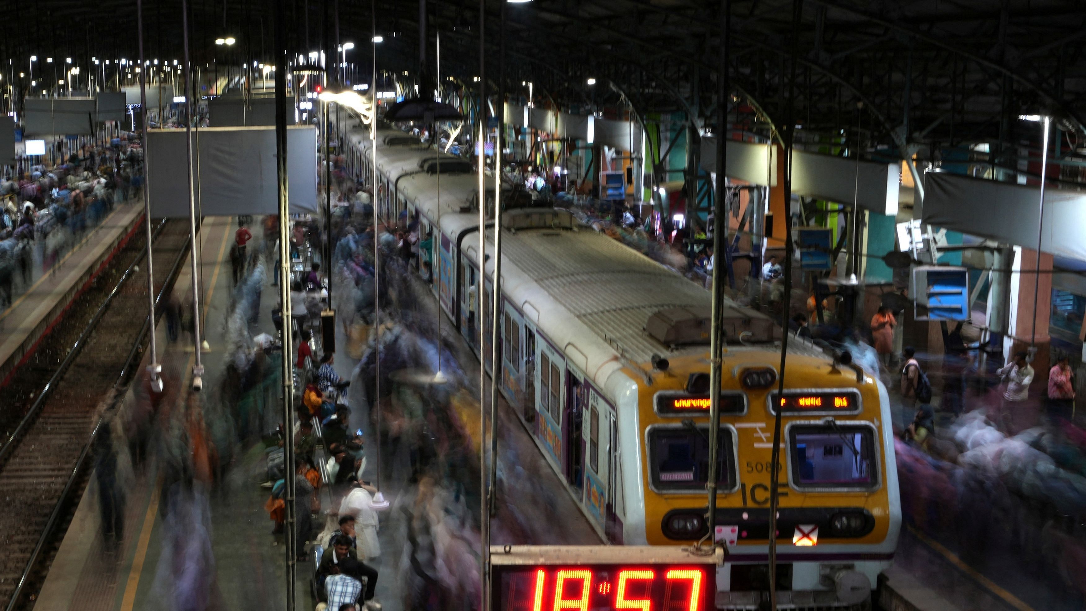 <div class="paragraphs"><p>Commuters walk after disembarking from suburban trains as others wait to board, at Churchgate railway station in Mumbai.</p></div>