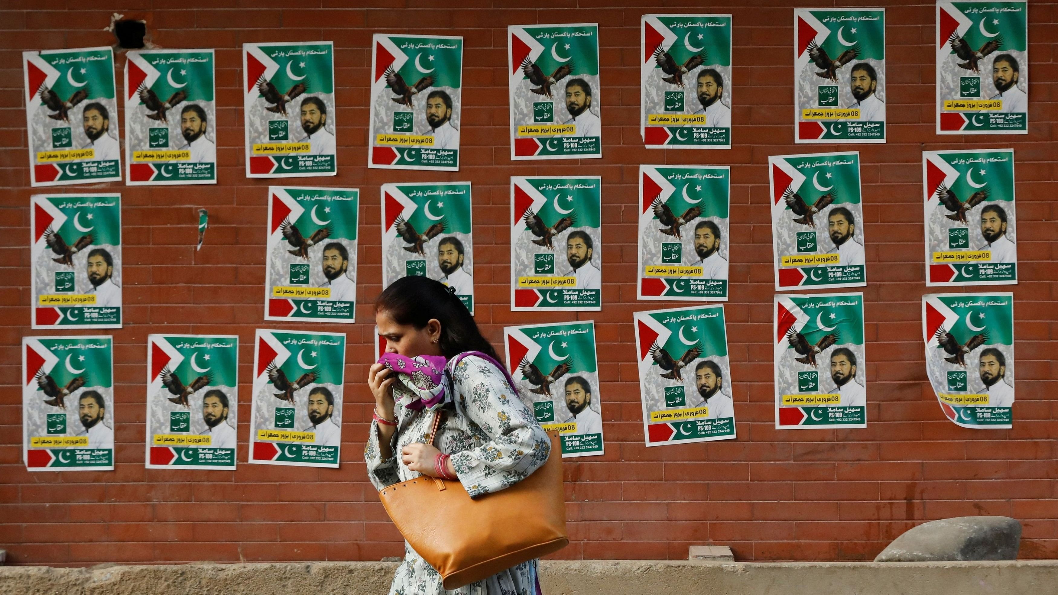 <div class="paragraphs"><p>A woman walks past a wall with the campaign posters of political party, ahead of general elections, in Karachi, Pakistan February 2, 2024. </p></div>