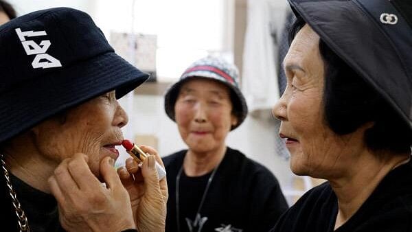 <div class="paragraphs"><p>Jang Ok-geum, 74, a member of the granny rap group 'Suni and Seven Princesses', applies makeup to their leader Park Jeom-sun, 81, at a rehearsal studio in Chilgok, South Korea, February 6, 2024.</p></div>