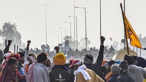 <div class="paragraphs"><p>Farmers raise slogans in front of security personnel guarding at the Punjab-Haryana Shambhu border during their 'Delhi Chalo' protest, near Patiala district, Friday, February 16, 2024.</p></div>