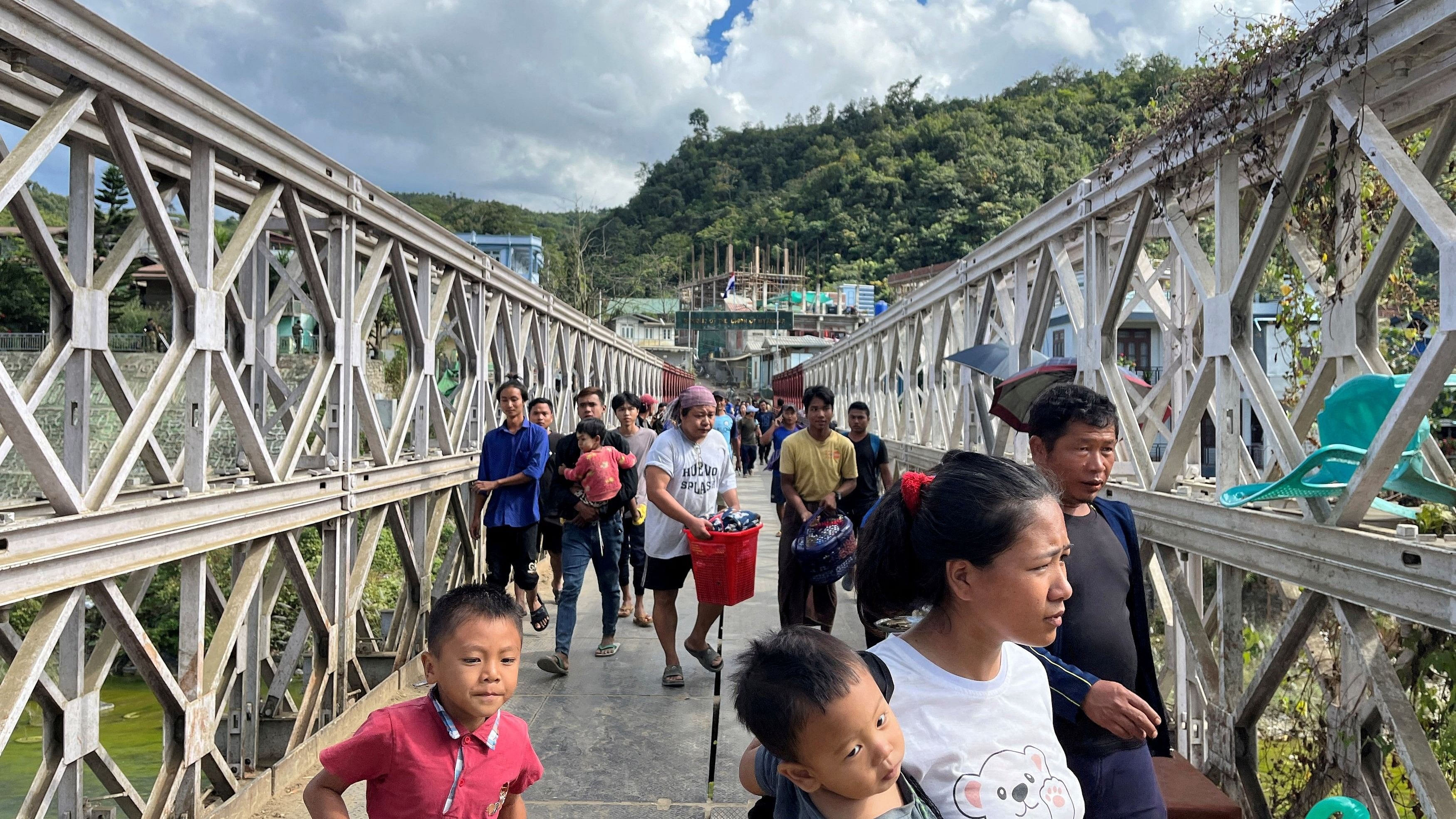 <div class="paragraphs"><p>People who fled Myanmar carry their belongings across a bridge that connects Myanmar and India at the border village of Zokhawthar, Mizoram.</p></div>