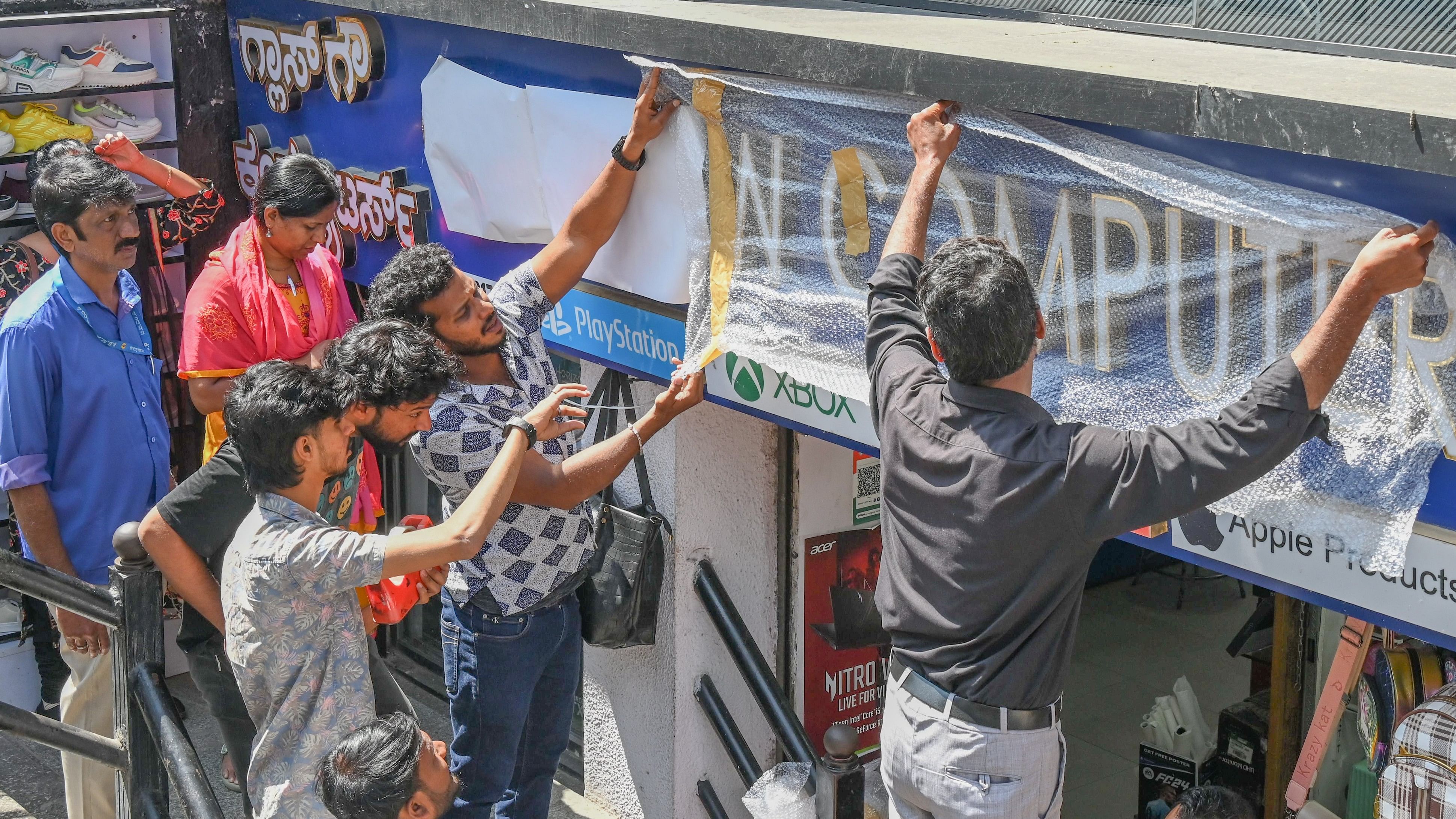 <div class="paragraphs"><p>BBMP officials instruct shop owners at Brigade Road to cover the signboards. </p></div>