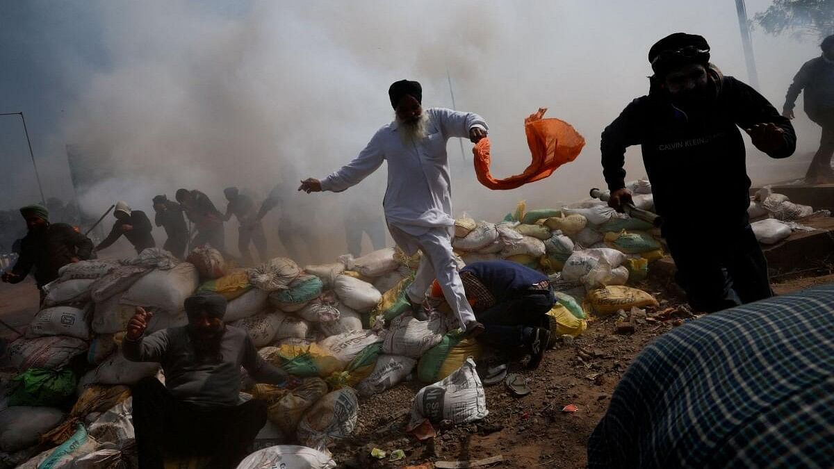 <div class="paragraphs"><p>Farmers, who are marching towards New Delhi to press for better crop prices promised to them in 2021, run for cover amidst tear gas fired by police to disperse them at Shambhu barrier, a border crossing between Punjab and Haryana states.</p></div>