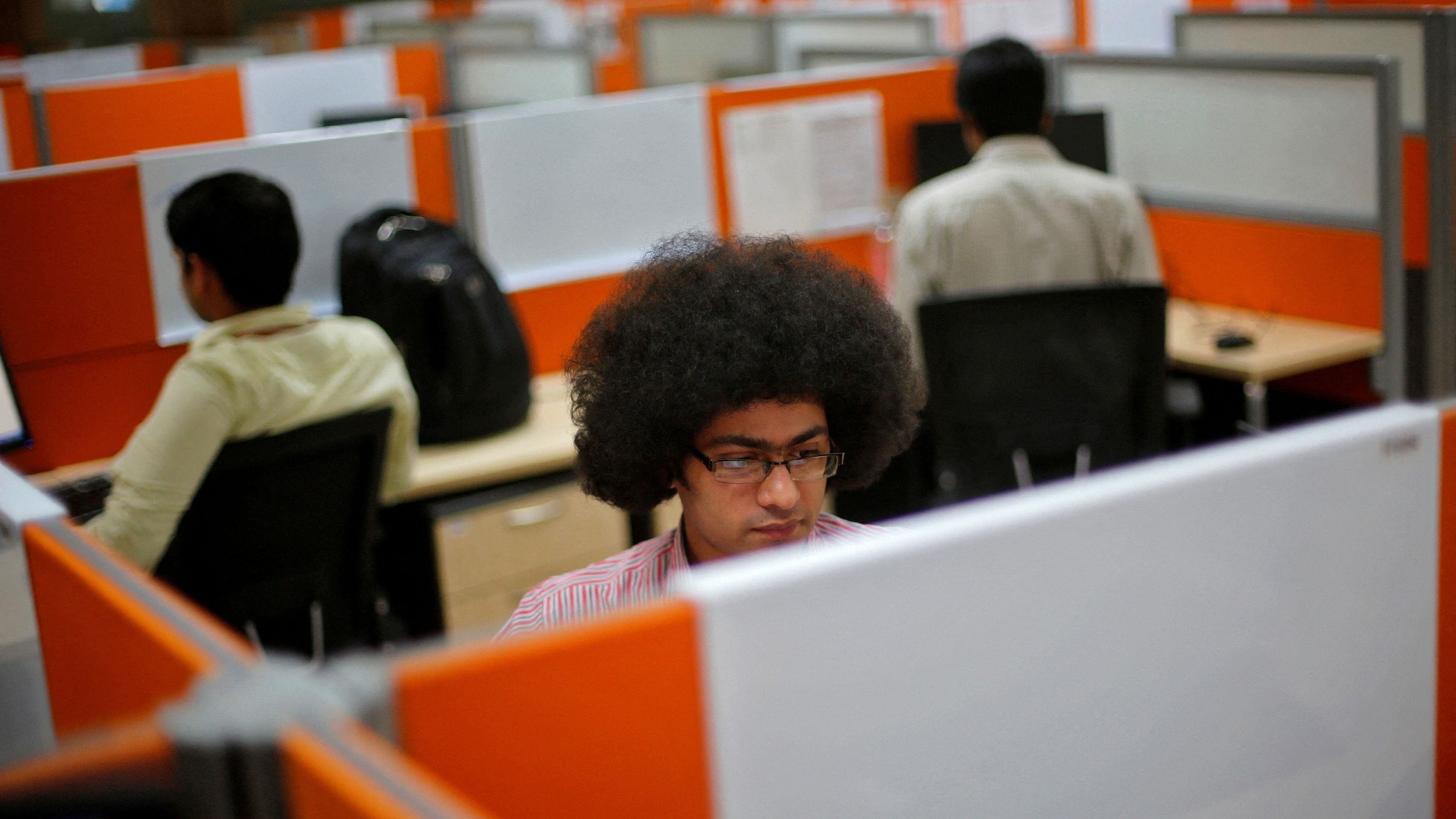 <div class="paragraphs"><p>FILE PHOTO: Employees work at their desks inside Tech Mahindra office building in Noida.</p></div>