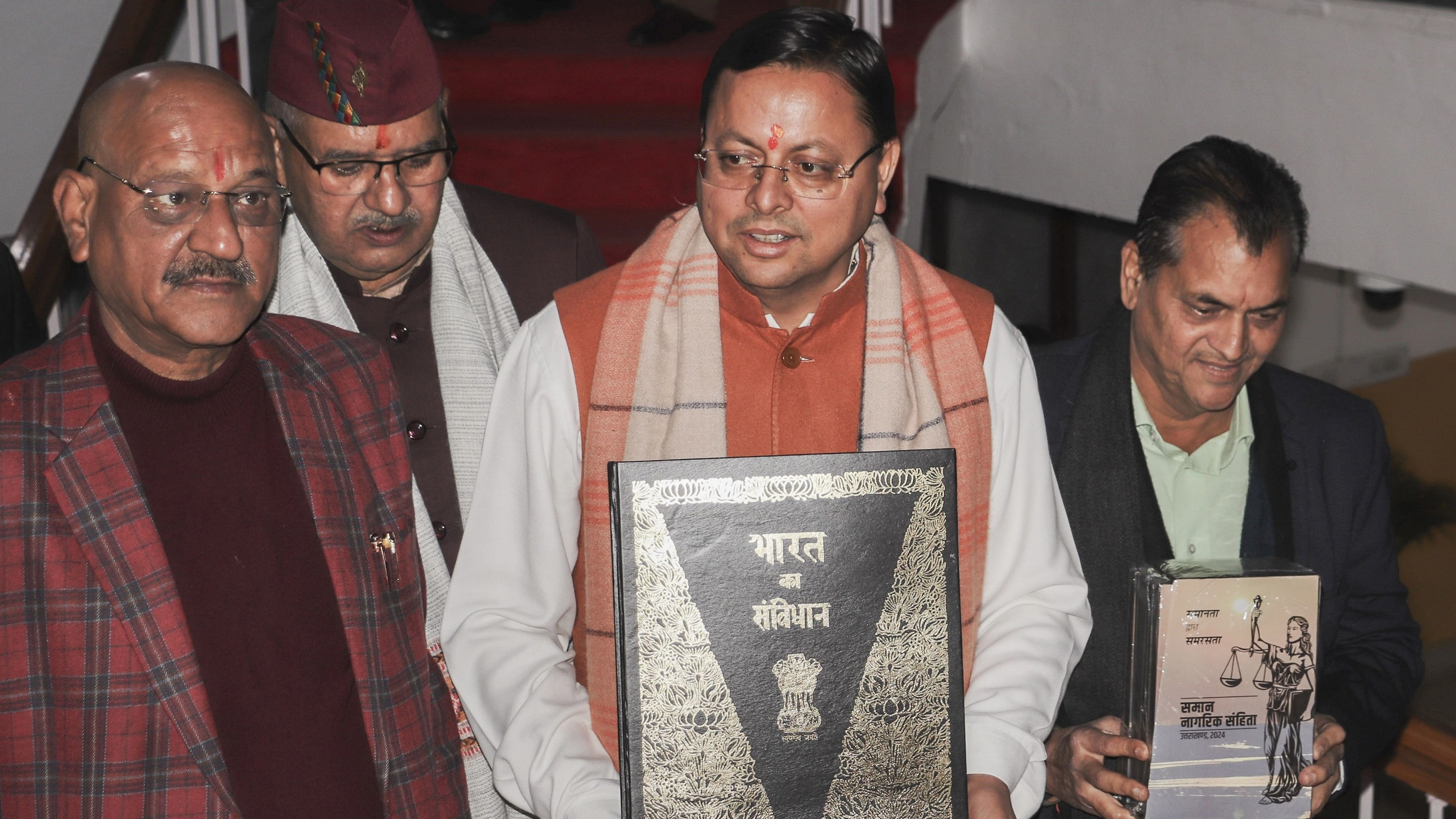 <div class="paragraphs"><p>Uttarakhand Chief Minister Pushkar Singh Dhami with others holds a copy of the Constitution of India, at Vidhan Sabha Bhawan, in Dehradun, Tuesday, Feb. 6, 2024. The Uniform Civil Code bill, which proposes uniform marriage, divorce, land, property and inheritance laws for all citizens irrespective of their religion in Uttarakhand, was tabled in the state assembly on Tuesday.</p></div>